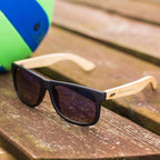 Schwarze Sonnenbrille mit Bambus-Bügeln und individueller Namensgravur, stilvolles Accessoire und persönliches Geschenk.